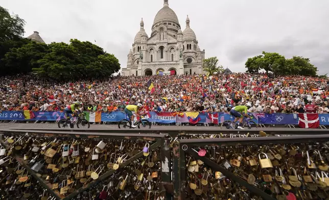 Cyclists ride past the Sacre Coeur basilica, during the men's road cycling event, at the 2024 Summer Olympics, Saturday, Aug. 3, 2024, in Paris, France. (AP Photo/Vadim Ghirda)