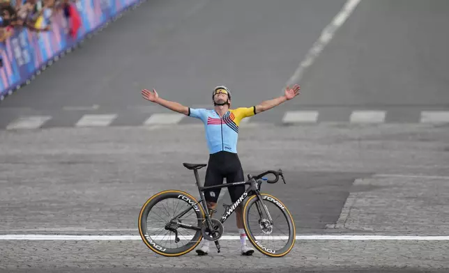 Remco Evenepoel, of Belgium, celebrates winning the men's road cycling event, at the 2024 Summer Olympics, Saturday, Aug. 3, 2024, in Paris, France. (AP Photo/Dar Yasin)