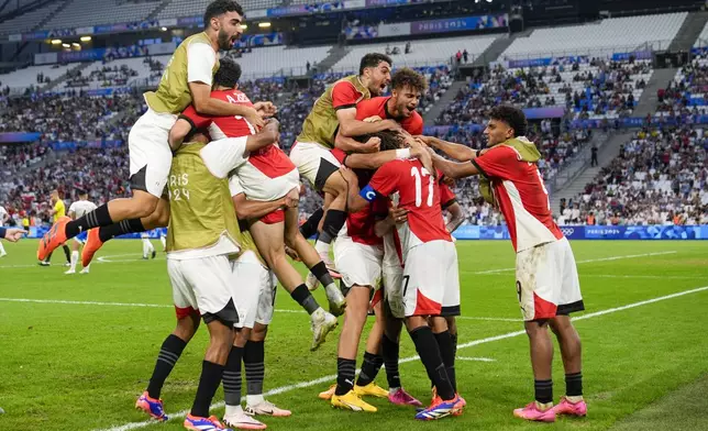 Egypt athletes react after Ibrahim Adel scored their side's first goal to tie the score 1-1 during a men's quarterfinal soccer match between Egypt and Paraguay at the 2024 Summer Olympics, Friday, Aug. 2, 2024, at Marseille Stadium in Marseille, France. (AP Photo/Julio Cortez)