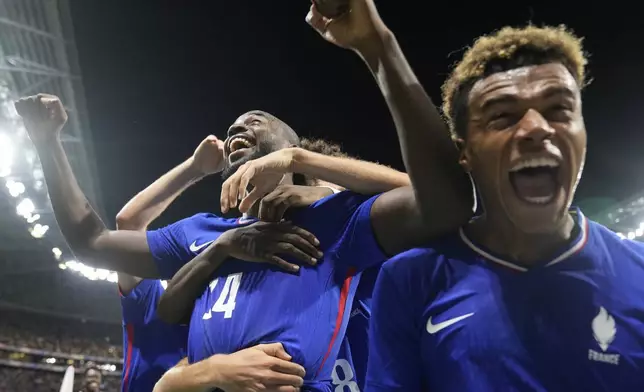 France's Jean-Philippe Mateta(14), left, celebrates with teammates after scoring his side's 2nd goal in extra time during the men's semifinal soccer match between France and Egypt, at Lyon Stadium, during the 2024 Summer Olympics, Monday, Aug. 5, 2024, in Decines, France. (AP Photo/Silvia Izquierdo)