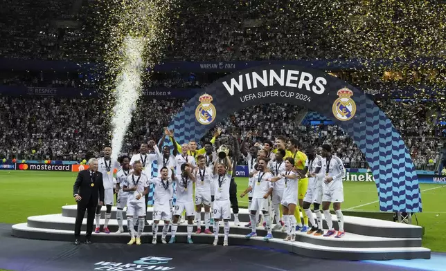 Real Madrid's team members celebrate with the trophy as they won the UEFA Super Cup Final soccer match between Real Madrid and Atalanta at the Narodowy stadium in Warsaw, Poland, Wednesday, Aug. 14, 2024. (AP Photo/Czarek Sokolowski)