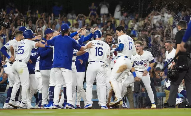 Los Angeles Dodgers designated hitter Shohei Ohtani (17) celebrates with teammates after hitting a grand slam during the ninth inning of a baseball game against the Tampa Bay Rays in Los Angeles, Friday, Aug. 23, 2024. The Dodgers won 7-3. (AP Photo/Ashley Landis)