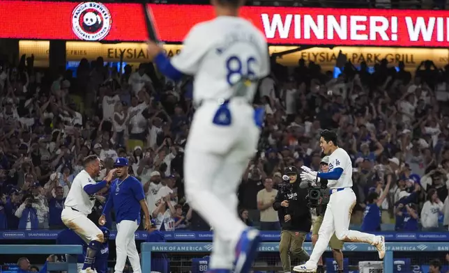 Los Angeles Dodgers designated hitter Shohei Ohtani, right, celebrates as he runs the bases after hitting a grand slam during the ninth inning of a baseball game against the Tampa Bay Rays in Los Angeles, Friday, Aug. 23, 2024. The Dodgers won 7-3. (AP Photo/Ashley Landis)