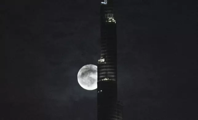 A supermoon rises behind the Burj Khalifa, world's tallest tower in Dubai, United Arab Emirates, Monday, Aug. 19, 2024. (AP Photo/Altaf Qadri)