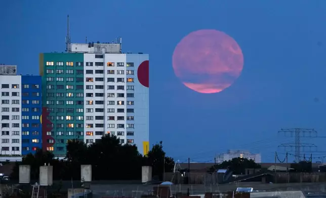 The supermoon rises from behind a resident building in Berlin, Monday, Aug. 19, 2024. (AP Photo/Markus Schreiber)