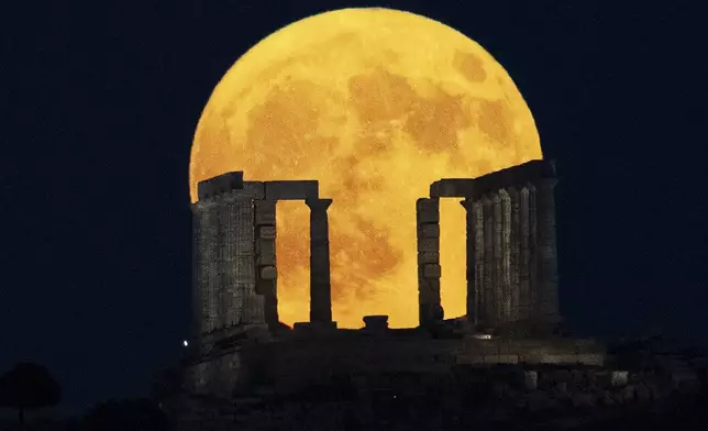 The super moon rises behind the Temple of Poseidon at Cape Sounio, south of Athens, Monday, Aug. 19, 2024. (AP Photo/Michael Varaklas)