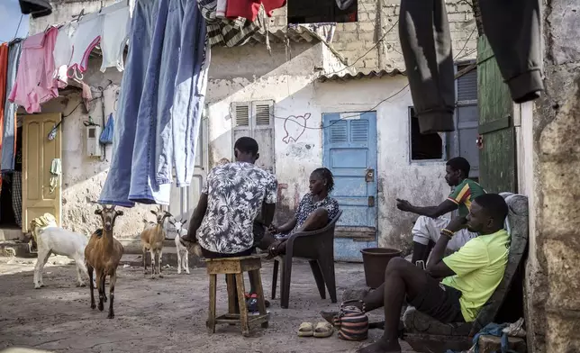 Salamba Ndiaye, center, a 28-year-old who tried to migrate to Europe twice, is photographed at her family house in Thiaroye-Sur-Mer, Senegal, Friday, Aug. 23, 2024. Ndiaye is one of thousands of young Senegalese who try to flee poverty and the lack of job opportunities in the West African country each year to head to Spain. More than 22,300 people have landed on the Canary Islands from January to mid-August this year. (AP Photo/Annika Hammerschlag)