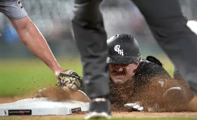 Chicago White Sox's Dominic Fletcher dives safely back to first after unsuccessfully trying to stretch his single into a double as Detroit Tigers first baseman Spencer Torkelson takes the throw from shortstop Trey Sweeney during the fourth inning of a baseball game Monday, Aug. 26, 2024, in Chicago. (AP Photo/Charles Rex Arbogast)