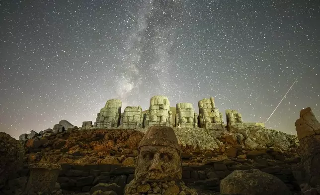 Ancient statues are seen during the Perseid meteor shower atop Mount Nemrut in southeastern Turkey, Monday, Aug.12, 2024. Perched at an altitude of 2,150 meters (over 7,000 feet), the statues are part of a temple and tomb complex that King Antiochus I, of the ancient Commagene kingdom, built as a monument to himself. (AP Photo/Emrah Gurel)