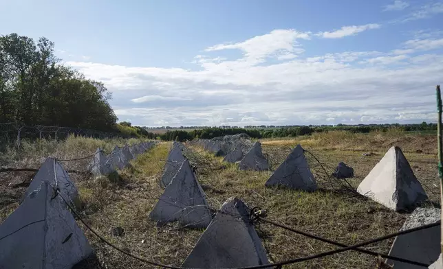 An anti-tank system known as "dragon teeth" covers a field on the Russian-Ukrainian border in the Sumy region of Ukraine, Tuesday, Aug. 13, 2024. (AP Photo/Evgeniy Maloletka)