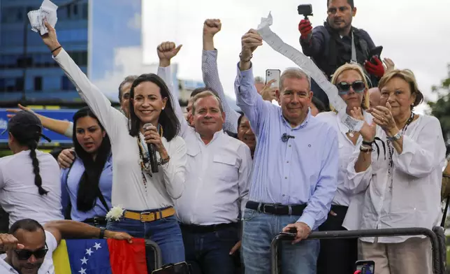 Opposition leader Maria Corina Machado, left, and opposition candidate Edmundo Gonzalez hold up vote tally sheets from the top of a truck during a protest against the official presidential election results declaring President Nicolas Maduro the winner in Caracas, Venezuela, on Tuesday, July 30, 2024, two days after the election. (AP Photo/Cristian Hernandez)