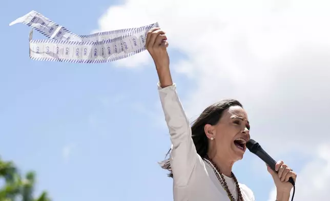 Opposition leader Maria Corina Machado displays vote tally sheets during a protest against the reelection of President Nicolás Maduro one month after the disputed presidential vote which she says the opposition won by a landslide, in Caracas, Venezuela, Wednesday, Aug. 28, 2024. (AP Photo/Ariana Cubillos)