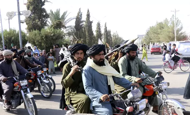 Taliban fighters celebrate the third anniversary of the withdrawal of US-led troops from Afghanistan, in Lashkar Gah, Helmand province, southwestern Afghanistan, Wednesday, Aug. 14, 2024. (AP Photo/Abdul Khaliq)