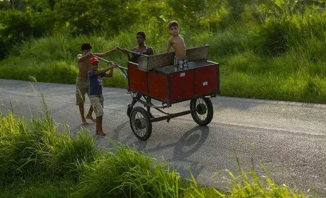 Children push a carriage in Campo Florido, east of Havana, Cuba, Monday, Aug. 12, 2024. (AP Photo/Ramon Espinosa)