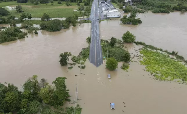 La Plata river floods a road after Tropical Storm Ernesto passed through Toa Baja, Puerto Rico, Wednesday, Aug. 14, 2024. (AP Photo/Alejandro Granadillo)