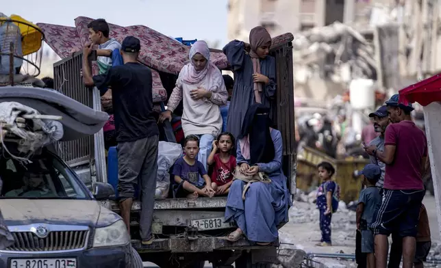 Palestinians displaced by the Israeli air and ground offensive on the Gaza Strip flee from Hamad City, following an evacuation order by the Israeli army to leave parts of the southern area of Khan Younis, Sunday, Aug. 11, 2024. (AP Photo/Abdel Kareem Hana)