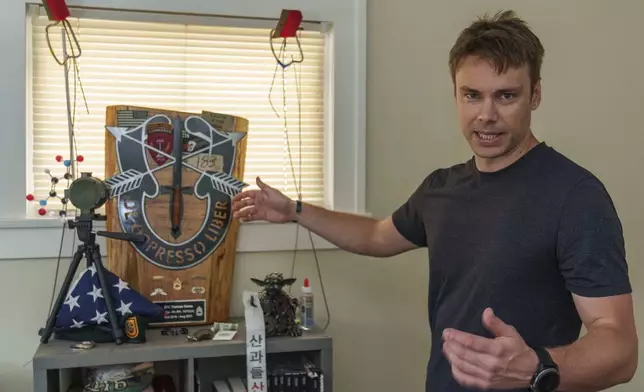 Thomas Kasza, a former Green Beret with over 13 years of service in both Afghanistan and Iraq, and now the executive director and founder of the 1208 Foundation, stands for a portrait with some of his military memorabilia in Long Beach, Calif., on Tuesday, Aug. 6, 2024. (AP Photo/Damian Dovarganes)