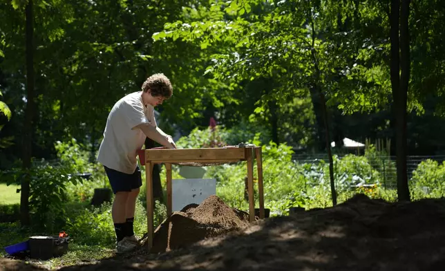 Alec Murillo sifts through dirt for artifacts while working at the site of an African burial ground in Kingston, N.Y., Monday, Aug. 5, 2024. (AP Photo/Seth Wenig)