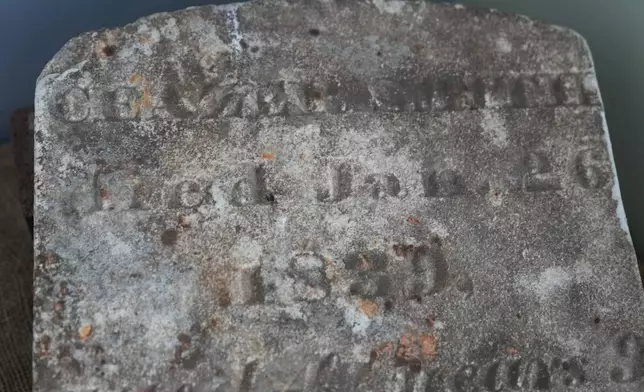 A tombstone bearing the name of Caezer Smith and dated 1839 is displayed on the site of a recently rediscovered African burial ground in Kingston, N.Y., Monday, Aug. 5, 2024. (AP Photo/Seth Wenig)