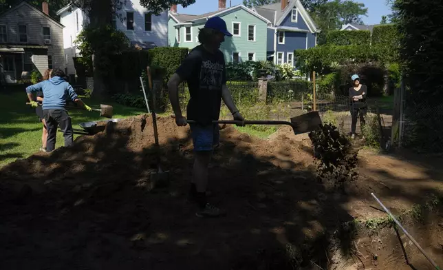 Students working at the site of an African burial ground, backfilling a hole they had dug, in Kingston, N.Y., Monday, Aug. 5, 2024. (AP Photo/Seth Wenig)