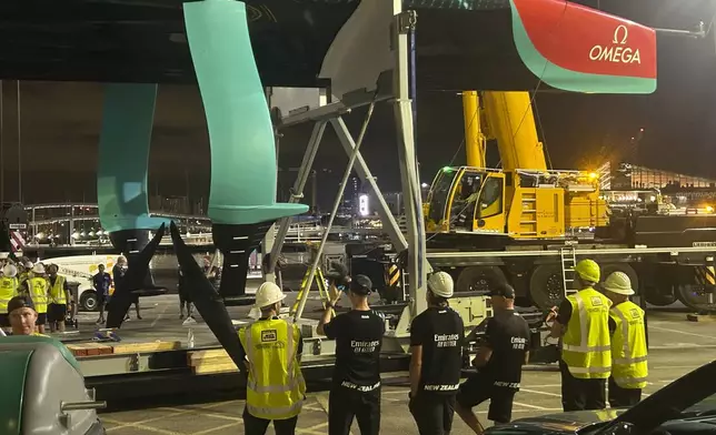 Emirates Team New Zealand inspects the team’s America’s Cup boat after it was damaged when a crane failed while moving it from the water to its cradle after the opening day of racing on Thursday Aug. 29, 2024 in Barcelona, Spain. (AP Photo/Joseph Wilson)