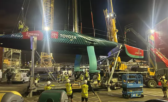 Emirates Team New Zealand inspects the team’s America’s Cup boat after it was damaged when a crane failed while moving it from the water to its cradle after the opening day of racing on Thursday Aug. 29, 2024 in Barcelona, Spain. (AP Photo/Joseph Wilson)