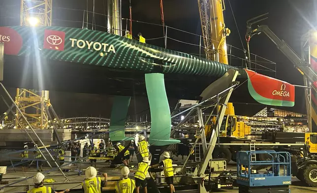 Emirates Team New Zealand inspects the team’s America’s Cup boat after it was damaged when a crane failed while moving it from the water to its cradle after the opening day of racing on Thursday Aug. 29, 2024 in Barcelona, Spain. (AP Photo/Joseph Wilson)