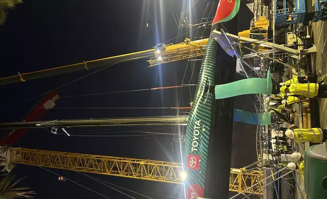 Emirates Team New Zealand inspects the team’s America’s Cup boat after it was damaged when a crane failed while moving it from the water to its cradle after the opening day of racing on Thursday Aug. 29, 2024 in Barcelona, Spain. (AP Photo/Joseph Wilson)