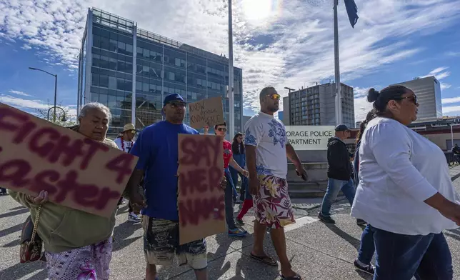 Attendees walk past the police headquarters during a march for Easter Leafa, a 16-year-old Samoan girl recently fatally shot by police, on Saturday, Aug. 17, 2024 in Anchorage, Alaska. (Loren Holmes/Anchorage Daily News via AP)