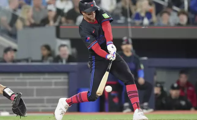 Toronto Blue Jays Ernie Clement hits an RBI single off Los Angeles Angels pitcher Jack Kochanowicz during fourth inning during a baseball game in Toronto, Friday Aug. 23, 2024. (Chris Young/The Canadian Press via AP)