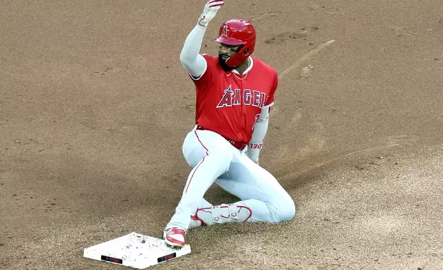 Los Angeles Angels ' Jo Adell slides into second base after hitting a two-RBI double against the Toronto Blue Jays during second-inning baseball game action in Toronto, Friday, Aug. 23, 2024. (Chris Young/The Canadian Press via AP)