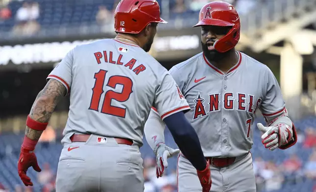 Los Angeles Angels' Jo Adell, right, is greeted by teammate Kevin Pillar at home plate on a two-run home run in which he also drove in Pillar during the second inning of a baseball game against the Washington Nationals, Friday, Aug. 9, 2024, in Washington. (AP Photo/John McDonnell)