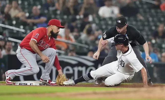 Los Angeles Angels third baseman Anthony Rendon tags Detroit Tigers' Kerry Carpenter as umpire Mike Estabrook looks on during the fifth inning of a baseball game, Wednesday, Aug. 28, 2024, in Detroit. (AP Photo/Carlos Osorio)