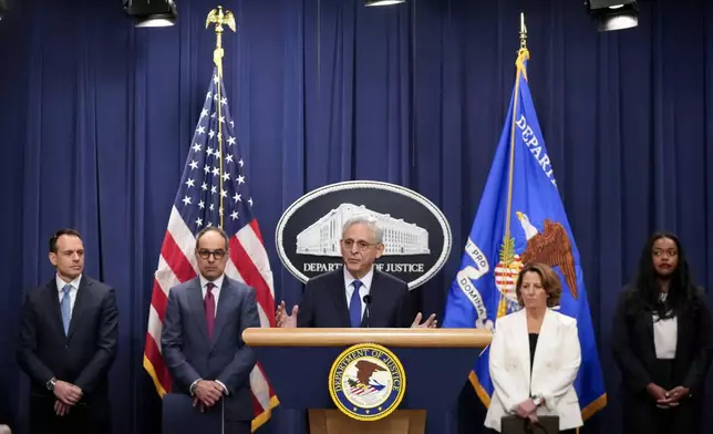 Attorney General Merrick Garland, center, speaks with reporters about an antitrust lawsuit against real estate software company RealPage during a news conference at the Department of Justice, Friday, Aug. 23, 2024, in Washington. (AP Photo/Mark Schiefelbein)