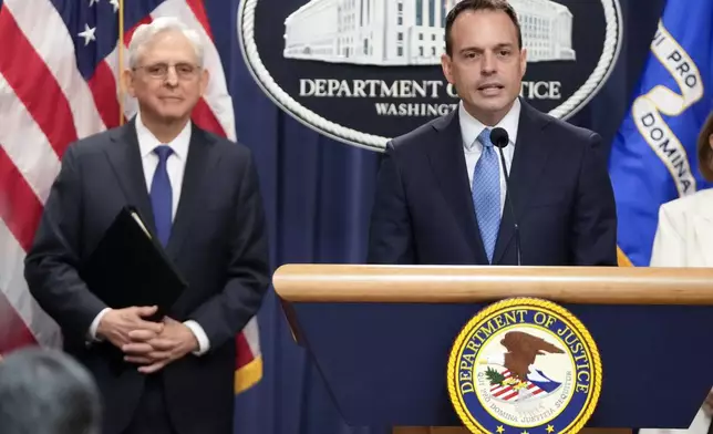 Acting Associate Attorney General Benjamin Mizer speaks with reporters about an antitrust lawsuit against real estate software company RealPage during a news conference at the Department of Justice, Friday, Aug. 23, 2024, in Washington. At left is Attorney General Merrick Garland. (AP Photo/Mark Schiefelbein)