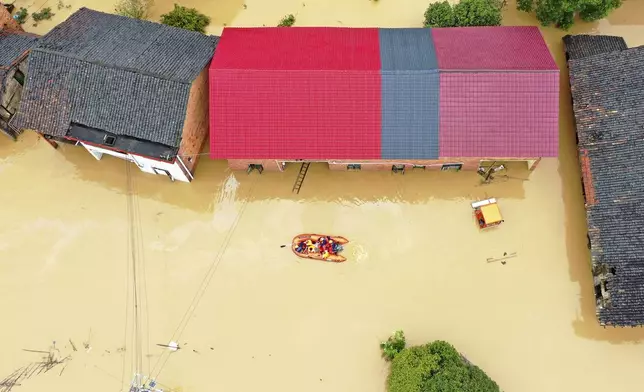 FILE - Rescuers use a dinghy boat to evacuate villagers trapped by floodwaters in Jingtang village, Zixing city, in southern China's Hunan province, on July 28, 2024. (Chinatopix via AP, File)