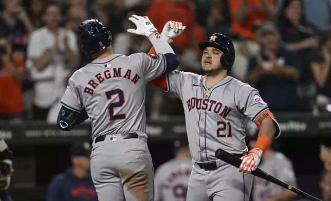 Houston Astros' Alex Bregman (2) is greeted at home plate by Yainer Diaz (21) after hitting a solo home run against Baltimore Orioles pitcher Burch Smith during the seventh inning of a baseball game, Sunday, Aug. 25, 2024, in Baltimore. (AP Photo/Terrance Williams)