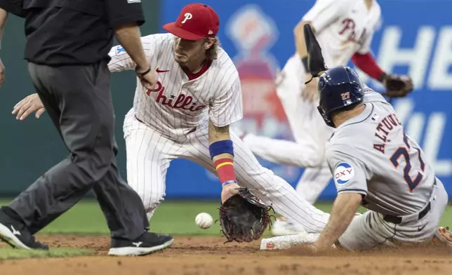 Houston Astros' Jose Altuve is safe on a steal on second before Philadelphia Phillies second baseman Bryson Stott can make the tag in the third inning of a baseball game, Tuesday, Aug. 27, 2024, in Philadelphia. (AP Photo/Laurence Kesterson)