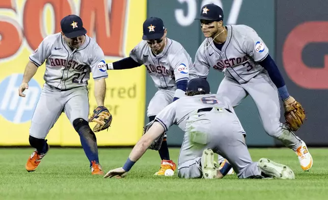 Houston Astros' Jose Altuve (27), Ben Gamel (12), Jeremy Pena (3) and Jake Meyers (6) scramble over a double hit by Philadelphia Phillies' Alec Bohm in the seventh inning of a baseball game, Tuesday, Aug. 27, 2024, in Philadelphia. (AP Photo/Laurence Kesterson)