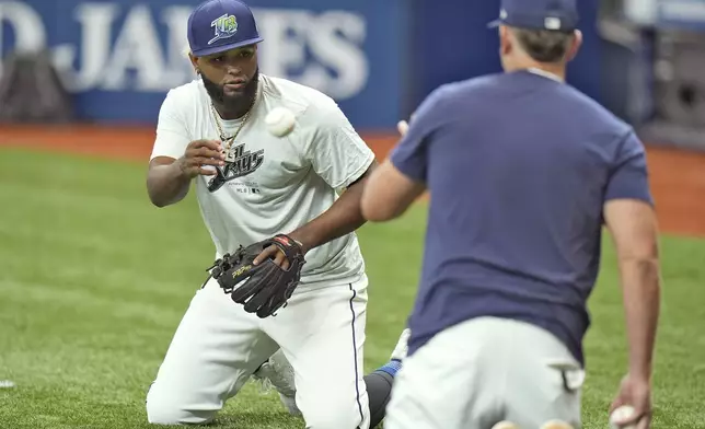 Newly called up Tampa Bay Rays third baseman Junior Caminero, left, works on drills with Brady Williams before a baseball game against the Houston Astros Tuesday, Aug. 13, 2024, in St. Petersburg, Fla. (AP Photo/Chris O'Meara)