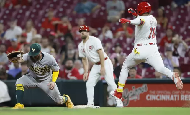 Oakland Athletics first baseman Seth Brown, left, catches the ball to get Cincinnati Reds' Noelvi Marte out at first base during the eighth inning of a baseball game, Tuesday, Aug. 27, 2024, in Cincinnati. (AP Photo/Jay LaPrete)