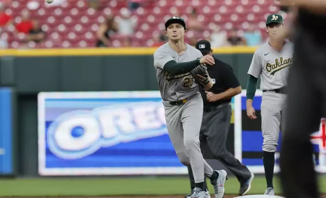 Oakland Athletics second baseman Zack Gelof turns a double play against Cincinnati Reds' Santiago Espinal and Jonathan India during the third inning of a baseball game, Tuesday, Aug. 27, 2024, in Cincinnati. (AP Photo/Jay LaPrete)