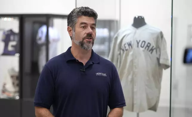 Mike Provenzale, Production manager at Heritage Auctions, talks about the 1932 Babe Ruth game worn New York Yankees World Series "Called Shot" jersey on display at Heritage Auctions in Irving, Texas, Wednesday, Aug. 21, 2024. (AP Photo/LM Otero)