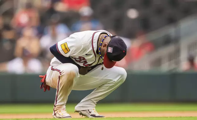 FILE - Atlanta Braves second baseman Ozzie Albies holds his wrist after an injury in the ninth inning of a baseball game against the St. Louis Cardinals, Sunday, July 21, 2024, in Atlanta. (AP Photo/Jason Allen, File)