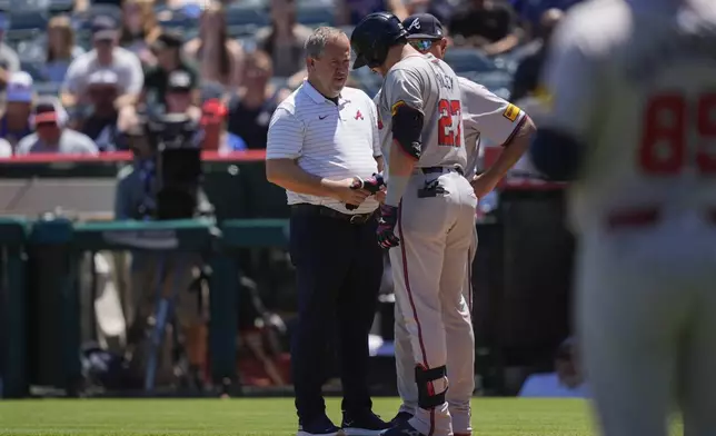 FILE - Atlanta Braves third baseman Austin Riley (27) is checked out after taking a pitch to the hand during the first inning of a baseball game against the Los Angeles Angels, Sunday, Aug. 18, 2024, in Anaheim, Calif. (AP Photo/Ryan Sun, File)