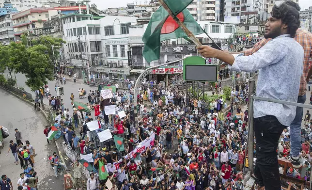 An activist waves Bangladesh flag during a protest march against Prime Minister Sheikh Hasina and her government to demand justice for the victims killed in the recent countrywide deadly clashes, in Dhaka, Bangladesh, Saturday, Aug. 3, 2024. (AP Photo/Rajib Dhar)