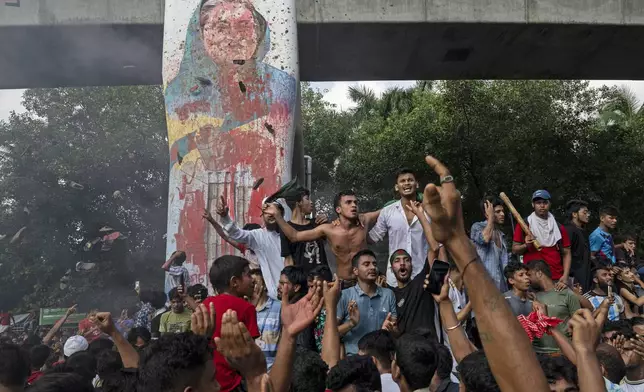 FILE - Protesters celebrate beside a defaced portrait of Prime Minister Sheikh Hasina after news of her resignation, in Dhaka, Bangladesh, on Aug. 5, 2024. (AP Photo/Fatima Tuj Johora,File)