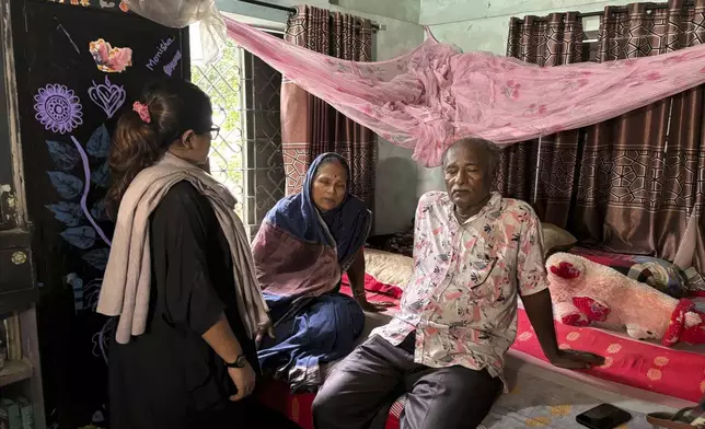 Arobinda Mohalder, right, talks with his wife, center, and another relative, in Dhaka, Bangladesh, Sunday, Aug. 11, 2024, after his nearby house was looted and burnt down. (AP Photo/Al-emrun Garjon)