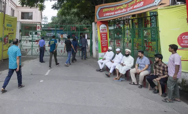 Muslim volunteers guard in front of the Dhakeshwari Hindu Temple in Dhaka, Bangladesh, Sunday, Aug.11, 2024. (AP Photo/Rajib Dhar)