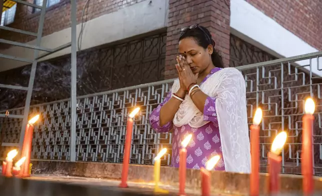 A Hindu woman prays at the Dhakeshwari National Temple in Dhaka, Bangladesh, Sunday, Aug.11, 2024. (AP Photo/Rajib Dhar)